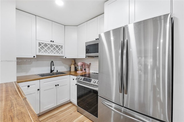 1520 Mckinley St Unit 206E, Hollywood, FL 33020 - kitchen with stainless steel appliances, a sink, wooden counters, and tasteful backsplash