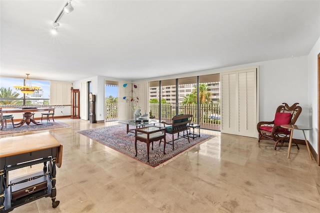 1 Grove Isle Dr Unit A409, Miami, FL 33133 - living area featuring healthy amount of natural light, track lighting, a wall of windows, and a chandelier