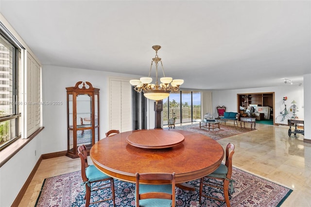 1 Grove Isle Dr Unit A409, Miami, FL 33133 - dining space with a chandelier and baseboards