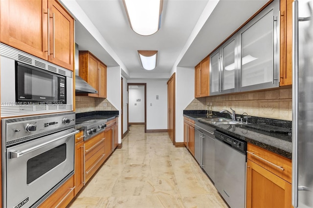 1 Grove Isle Dr Unit A409, Miami, FL 33133 - kitchen with stainless steel appliances, decorative backsplash, dark stone countertops, wall chimney exhaust hood, and brown cabinetry