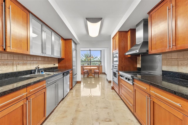 1 Grove Isle Dr Unit A409, Miami, FL 33133 - kitchen with wall chimney exhaust hood, built in appliances, brown cabinetry, tasteful backsplash, and dark stone counters