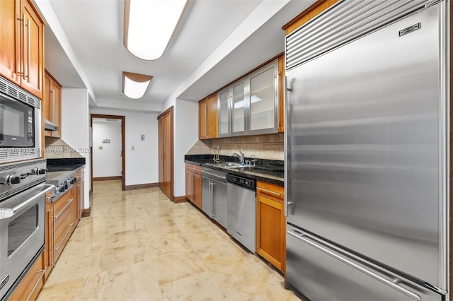 1 Grove Isle Dr Unit A409, Miami, FL 33133 - kitchen with built in appliances, decorative backsplash, baseboards, and brown cabinetry