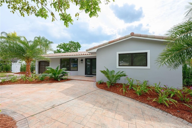 ranch-style house with stucco siding and a tile roof