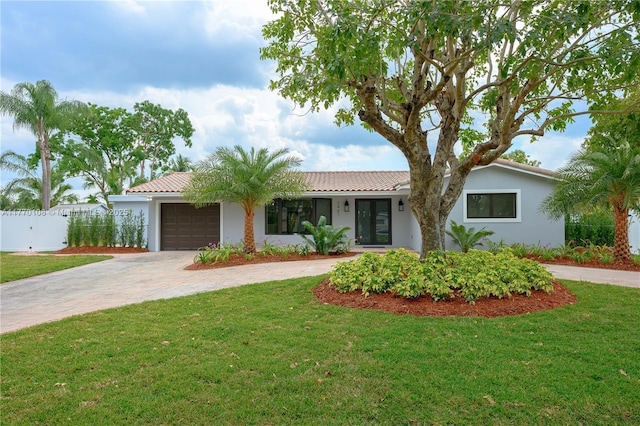 single story home featuring fence, a garage, a front yard, stucco siding, and driveway