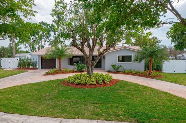 single story home featuring a gate, curved driveway, stucco siding, and fence