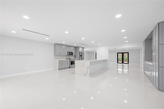 kitchen featuring modern cabinets, gray cabinets, a sink, and stainless steel appliances