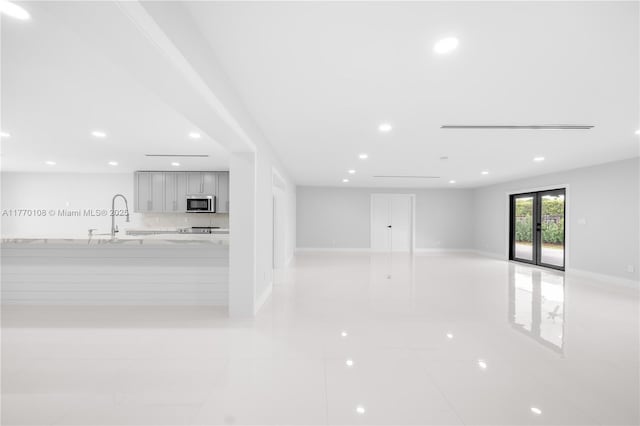 unfurnished room featuring baseboards, recessed lighting, and a sink