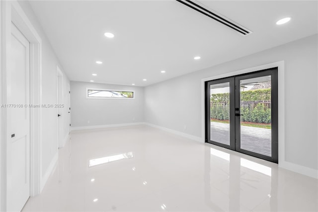 empty room with a wealth of natural light, french doors, and recessed lighting