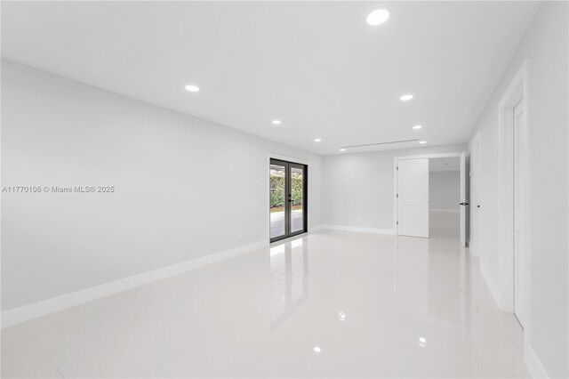 empty room featuring baseboards and recessed lighting
