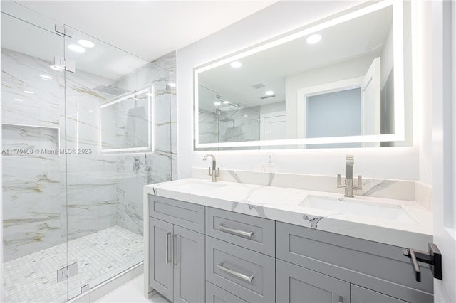 full bathroom featuring a marble finish shower, double vanity, a sink, and recessed lighting