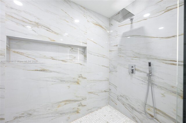 bathroom featuring a marble finish shower