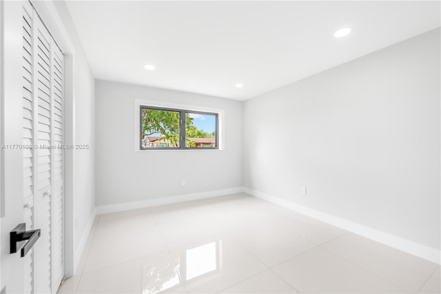 tiled empty room with baseboards and recessed lighting