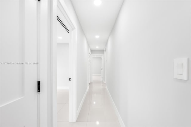 hallway featuring light tile patterned flooring, baseboards, and recessed lighting