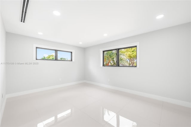 spare room with plenty of natural light, baseboards, visible vents, and recessed lighting