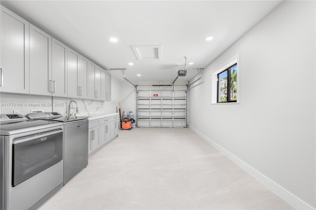 garage featuring a garage door opener, washing machine and clothes dryer, baseboards, and recessed lighting