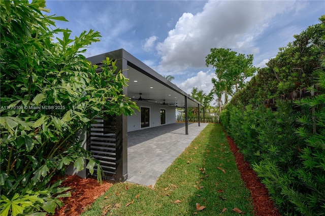 view of yard with ceiling fan, fence, and a patio area