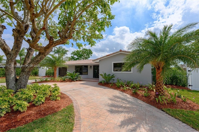 single story home with stucco siding and a tile roof