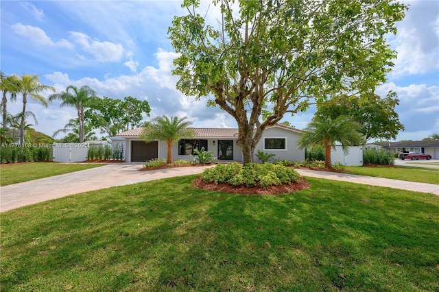 ranch-style house featuring a tile roof, concrete driveway, fence, a front lawn, and a garage