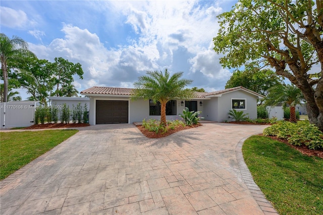single story home with fence, decorative driveway, a garage, and stucco siding