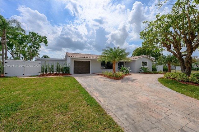 ranch-style house featuring a tile roof, a front yard, stucco siding, decorative driveway, and a garage