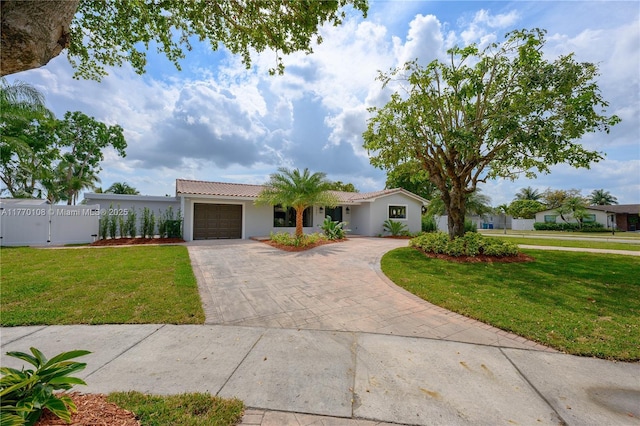 view of front of property with driveway, an attached garage, a front lawn, and a tiled roof