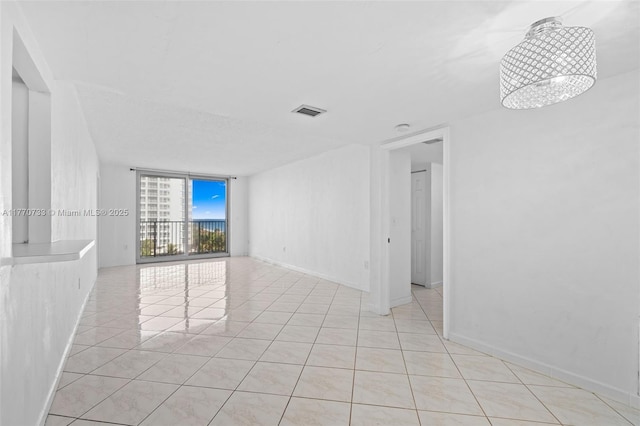 9273 Collins Ave Unit 607, Surfside, FL 33154 - spare room featuring light tile patterned flooring, baseboards, a wall of windows, and visible vents