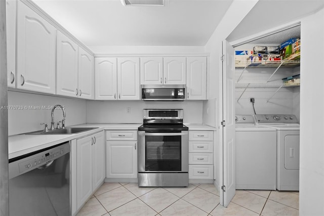 9273 Collins Ave Unit 607, Surfside, FL 33154 - kitchen with light countertops, appliances with stainless steel finishes, white cabinetry, a sink, and washer and dryer