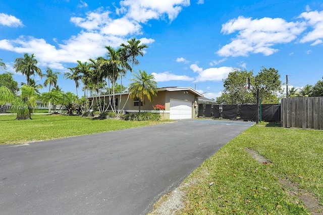 8480 Caribbean Blvd, Cutler Bay, FL 33157 - view of front of house with fence, a garage, stucco siding, a front lawn, and driveway