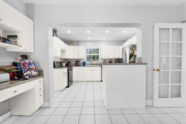 8480 Caribbean Blvd, Cutler Bay, FL 33157 - kitchen with light tile patterned flooring, black range, recessed lighting, white cabinetry, and freestanding refrigerator