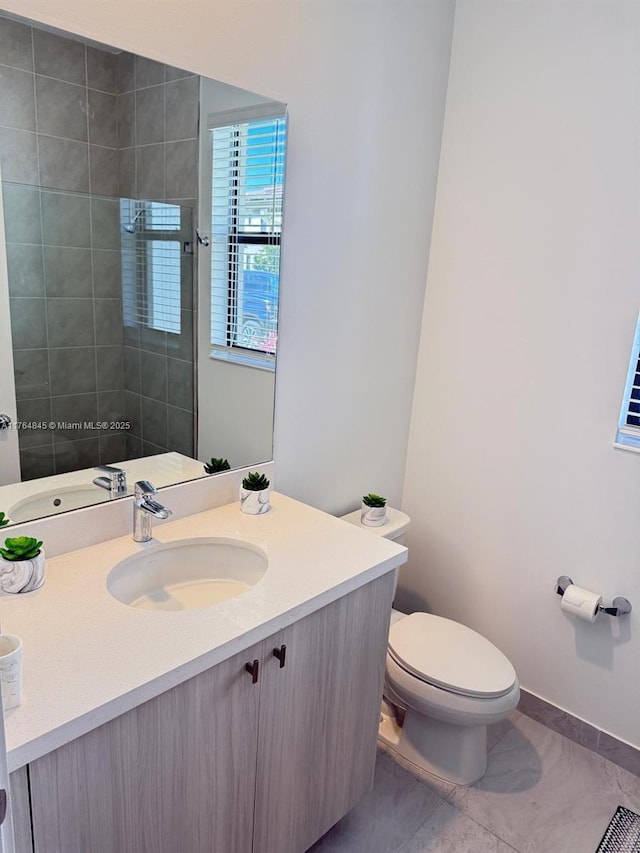 bathroom with baseboards, toilet, and vanity