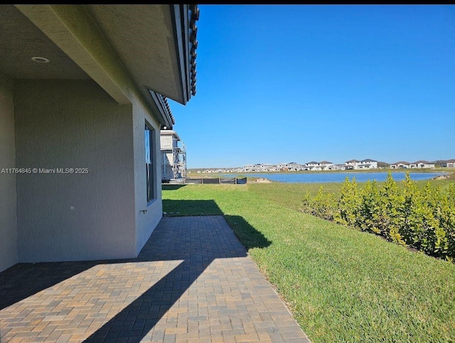 view of yard featuring a water view and a patio area