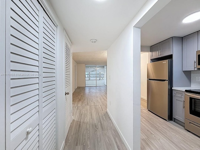 hallway with baseboards and light wood-style floors
