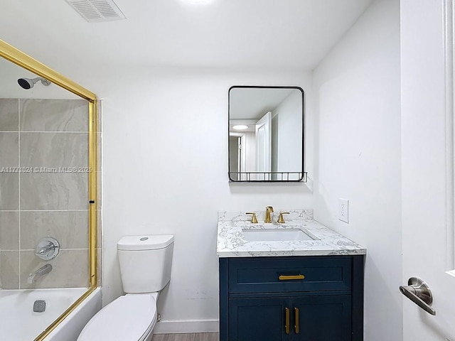 bathroom featuring toilet, vanity, shower / bathtub combination, baseboards, and visible vents