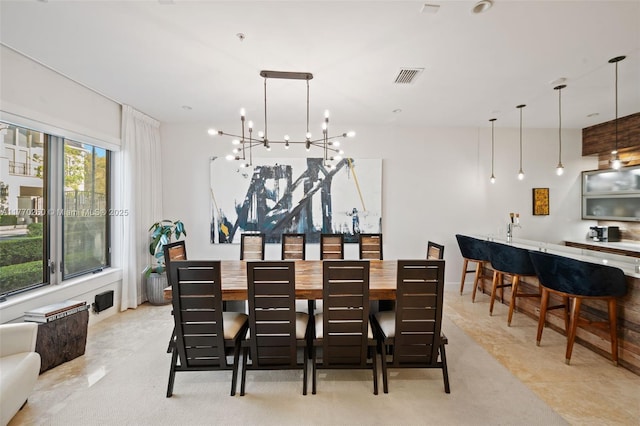 dining area with baseboards, visible vents, bar, and an inviting chandelier