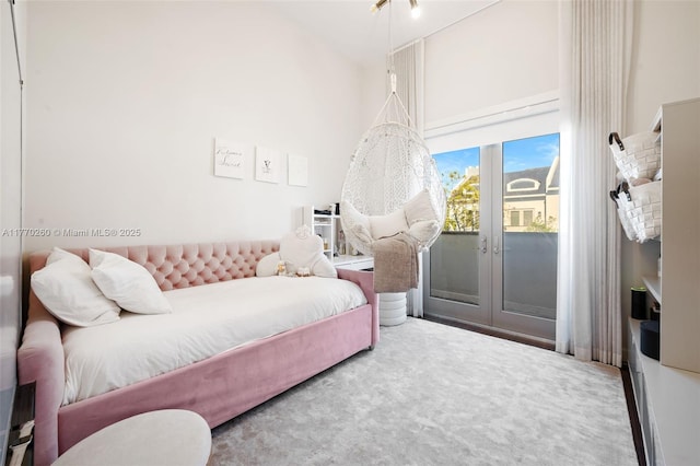 bedroom with french doors, a towering ceiling, carpet, and access to exterior