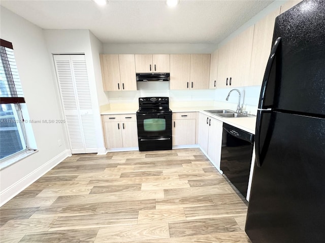 kitchen with a sink, light countertops, black appliances, and extractor fan
