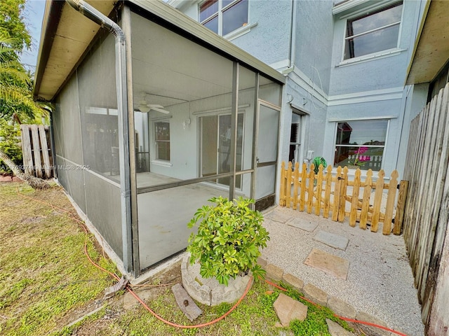 property entrance featuring fence, stucco siding, and a patio area