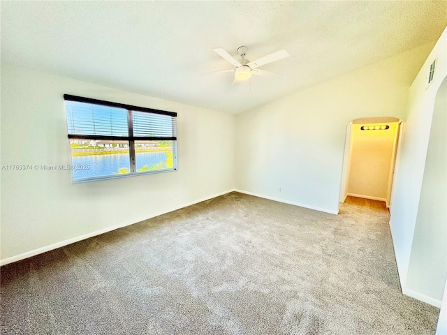 carpeted spare room featuring baseboards and a ceiling fan