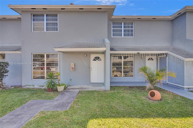 view of front of home with stucco siding and a front lawn