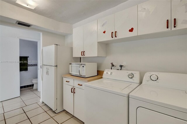 laundry area with washing machine and clothes dryer, light tile patterned flooring, laundry area, and visible vents