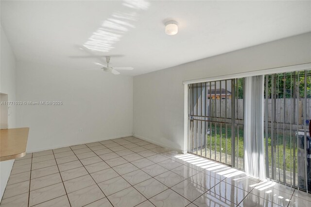 spare room featuring light tile patterned flooring, a ceiling fan, and a healthy amount of sunlight