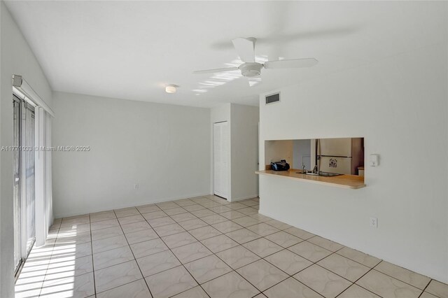 unfurnished room featuring a sink, ceiling fan, and visible vents