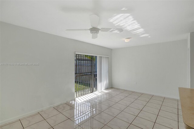 spare room with light tile patterned flooring, baseboards, and ceiling fan