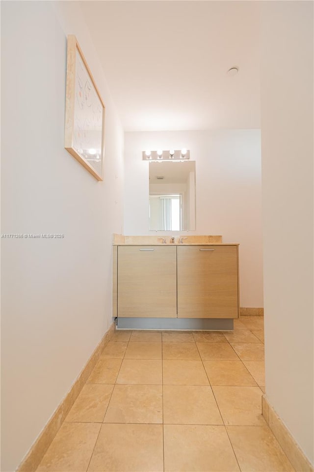 bathroom with tile patterned floors, baseboards, and vanity