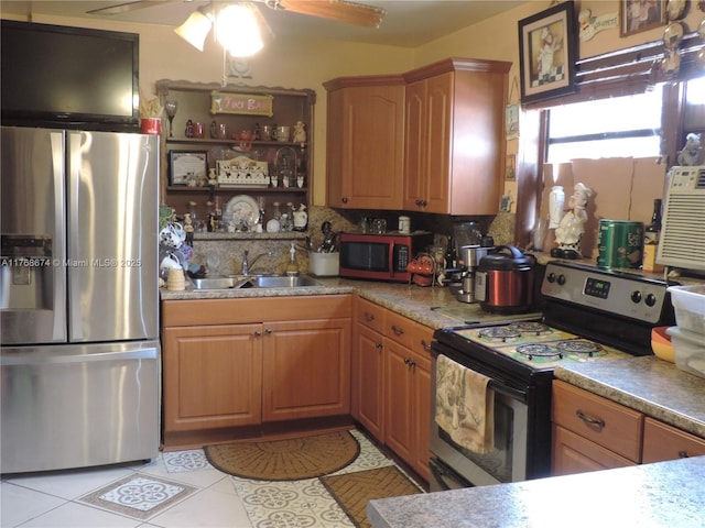 kitchen featuring ceiling fan, a sink, stainless steel appliances, and light tile patterned floors