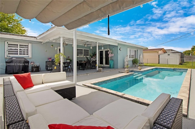 view of pool with an outdoor living space, grilling area, a patio area, ceiling fan, and fence