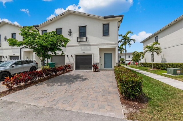 view of front facade featuring stucco siding, an attached garage, and decorative driveway