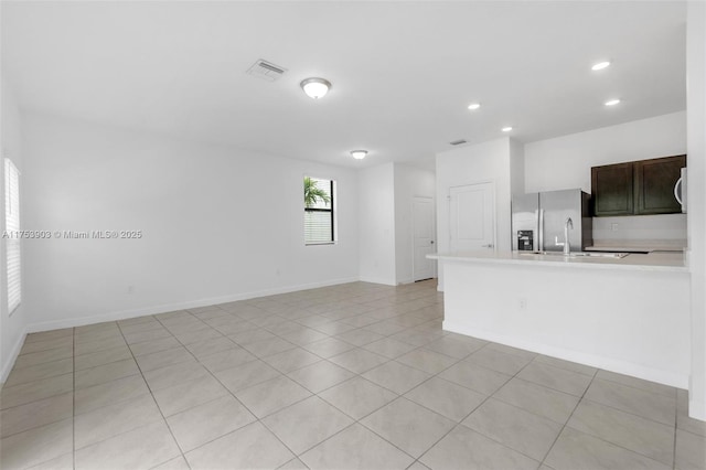 unfurnished living room with light tile patterned floors, recessed lighting, baseboards, and visible vents