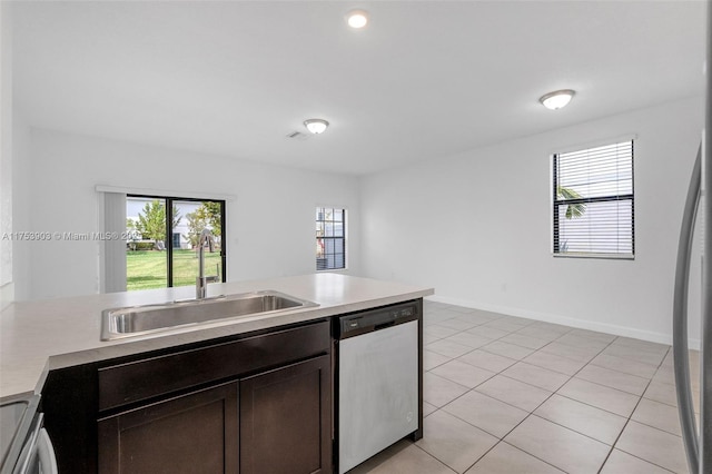 kitchen with light countertops, dark brown cabinetry, a sink, appliances with stainless steel finishes, and plenty of natural light