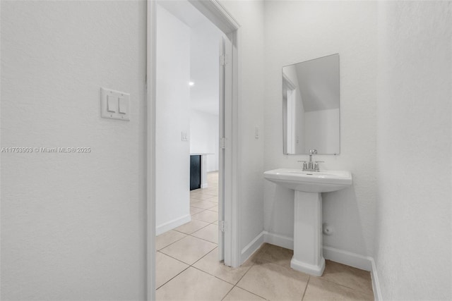 bathroom with baseboards and tile patterned flooring